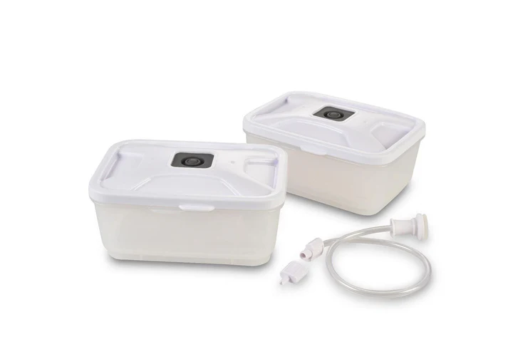 Dwa białe prostokątne pojemniki do przechowywania żywności z pokrywkami i wężem z łącznikami na białym tle.