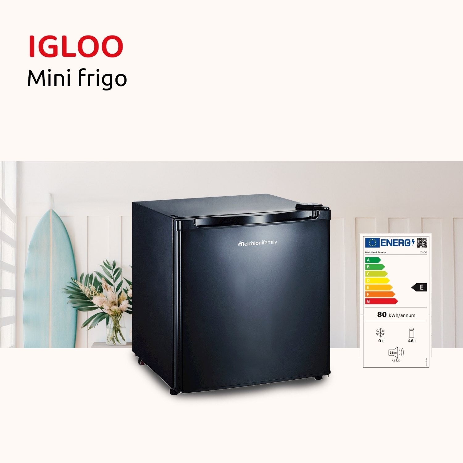 Mini frigo Igloo nero. Tavola da surf e fiori sullo sfondo. Etichetta energetica a destra.
