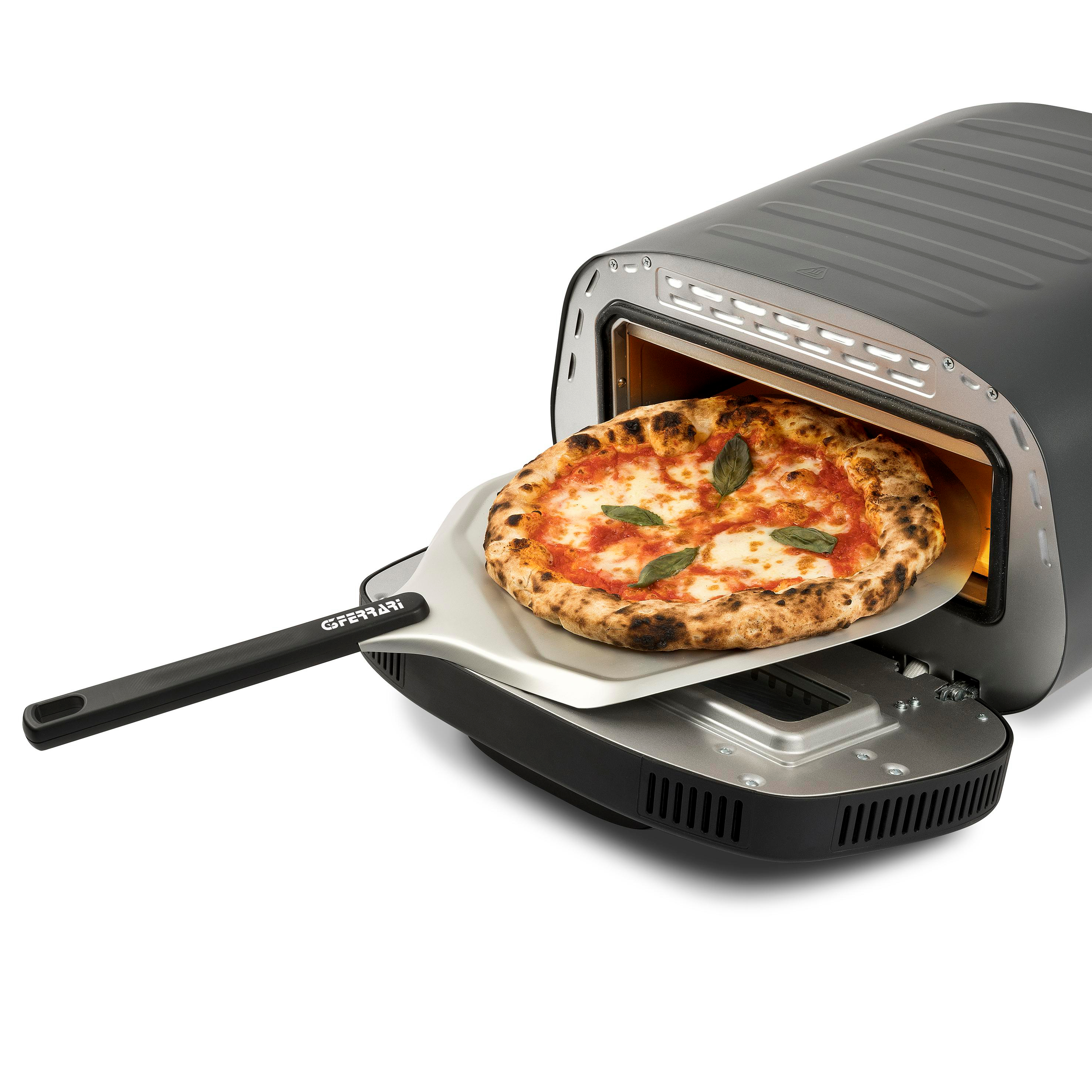 Eine Pizza wird auf einen Pizzaschieber gelegt und in einen Pizzaofen gelegt. Die Pizza hat Basilikum und Tomatensauce. Der Ofen ist schwarz.
