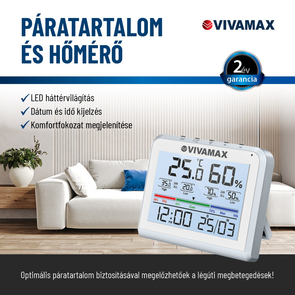 A Vivamax digitális higrométer a hőmérsékletet, a páratartalmat és az időt mutatja. Egy nappaliban van, kanapéval, növénnyel és kék párnával.