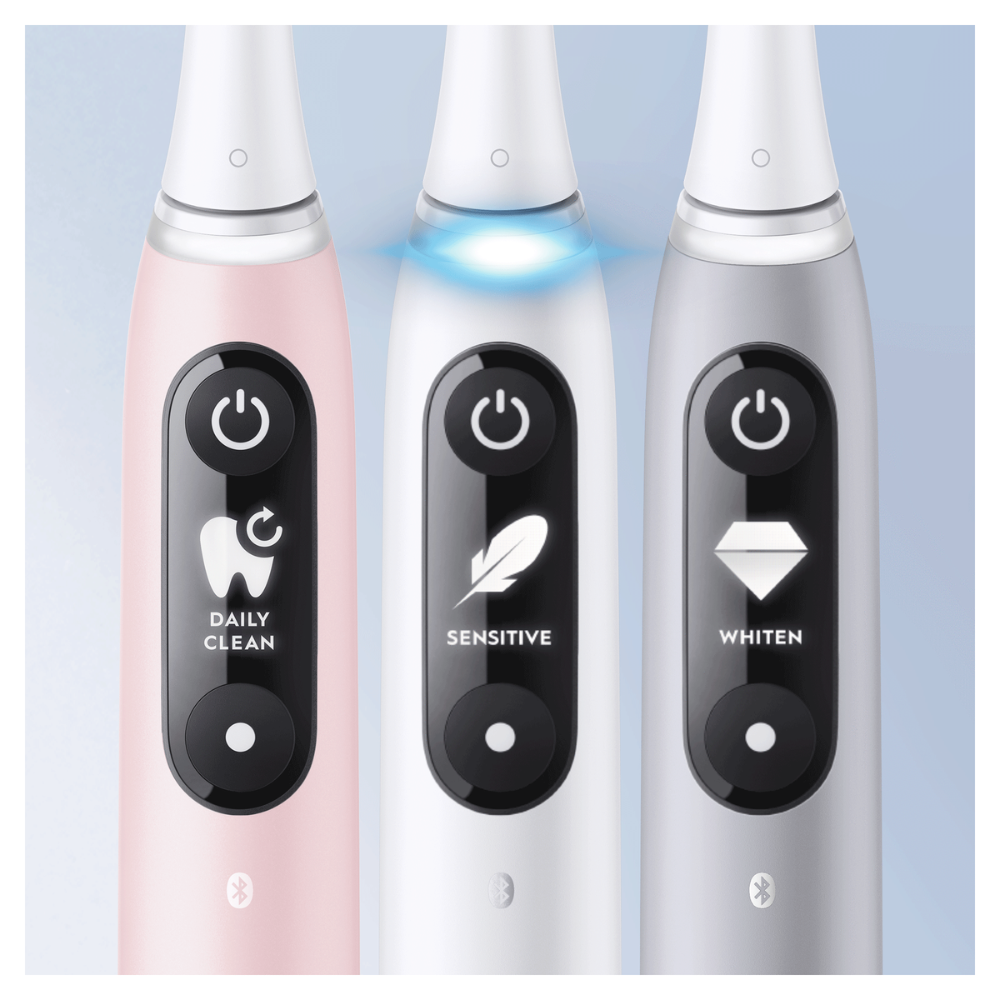 Tres cepillos de dientes eléctricos: rosa, blanco y plateado. Cada uno tiene una pantalla de modo: Daily Clean, Sensitive y Whiten. Botones de encendido visibles.