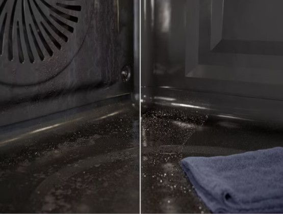 Wnętrze ciemnego piekarnika. Lewa strona pokazuje wentylator, dół jest brudny. Prawa strona pokazuje ciemny panel i niebieski ręcznik.