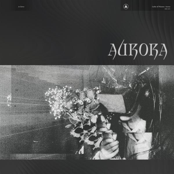 Albumcover mit dem Namen „Aurora“. Darunter ein Blumenstrauß. Der Hintergrund ist dunkel mit einem strukturierten Effekt.