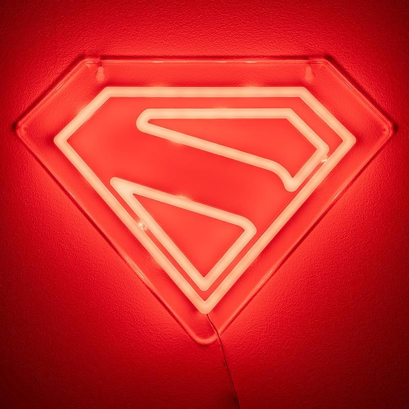 Piros falon neon Superman logó. A logó egy fehér 'S' a rombusz alakban. A fal textúrált.