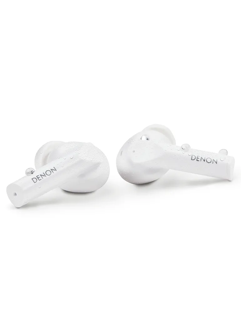 Dwa białe słuchawki Denon na białym tle. Krople wody są widoczne na powierzchniach, sugerując odporność na wodę.