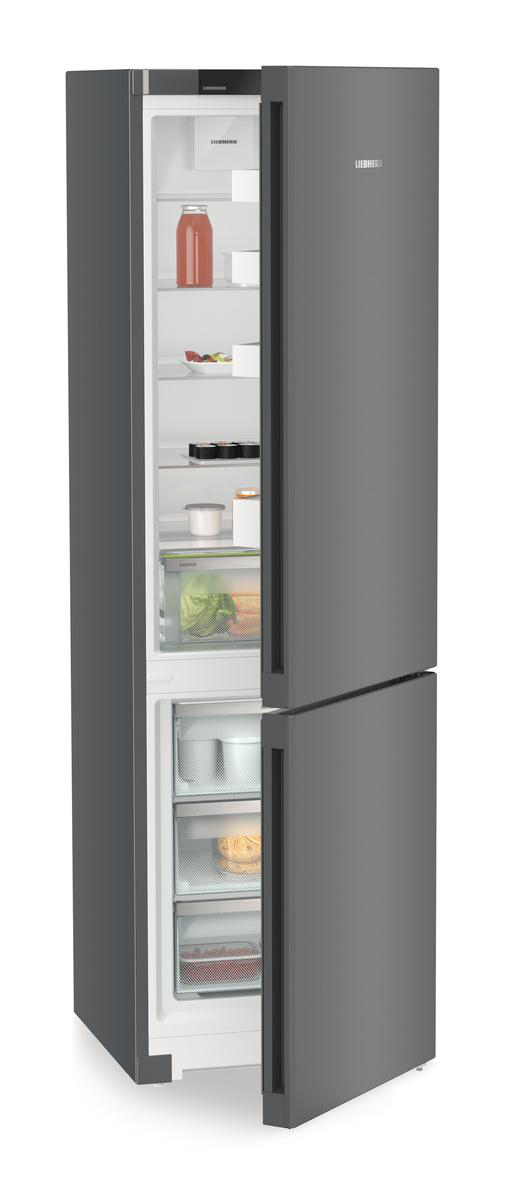 Ein dunkelgrauer Liebherr-Kühlschrank ist mit geöffneter Tür abgebildet. Im Inneren befinden sich Regale mit Lebensmitteln wie Saft, Gemüse und Behältern.
