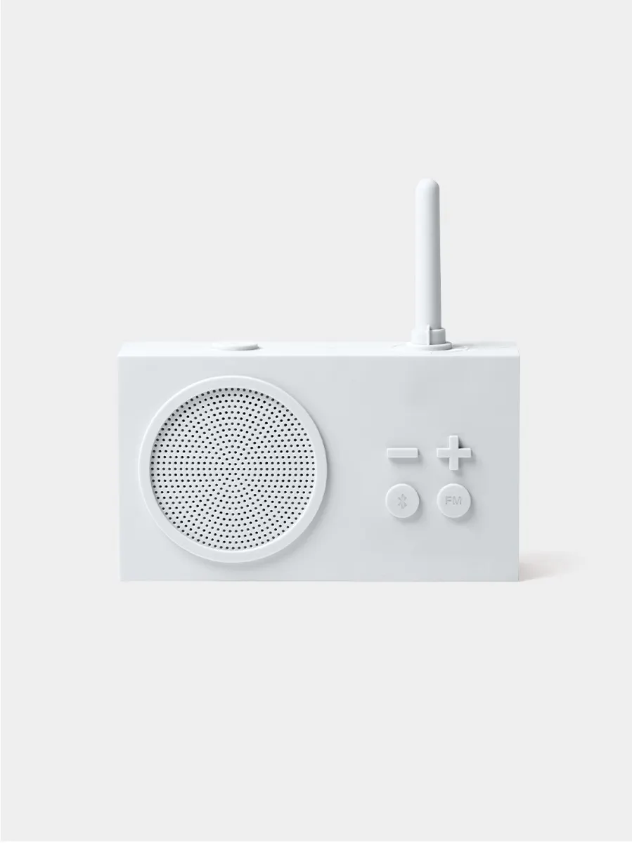 Ein weißes Radio mit Lautsprecher, Knöpfen und Antenne. Der Hintergrund ist einfarbig weiß. Das Radio ist einfach.