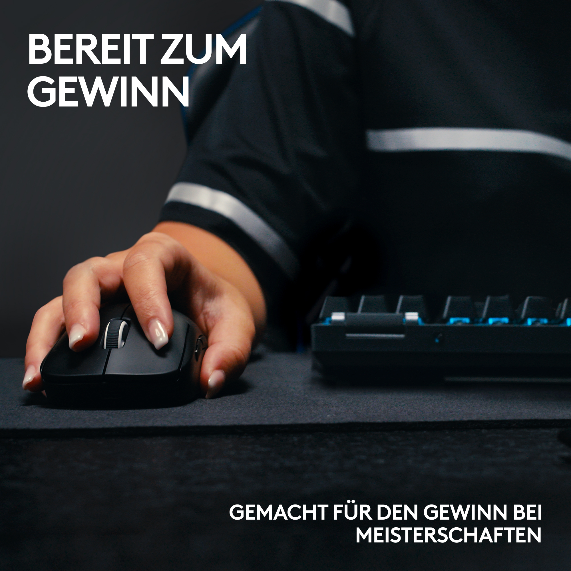 Eine Hand hält eine schwarze Maus in der Nähe einer Tastatur. Das Bild ist eine Produktaufnahme, mit Text auf Deutsch.