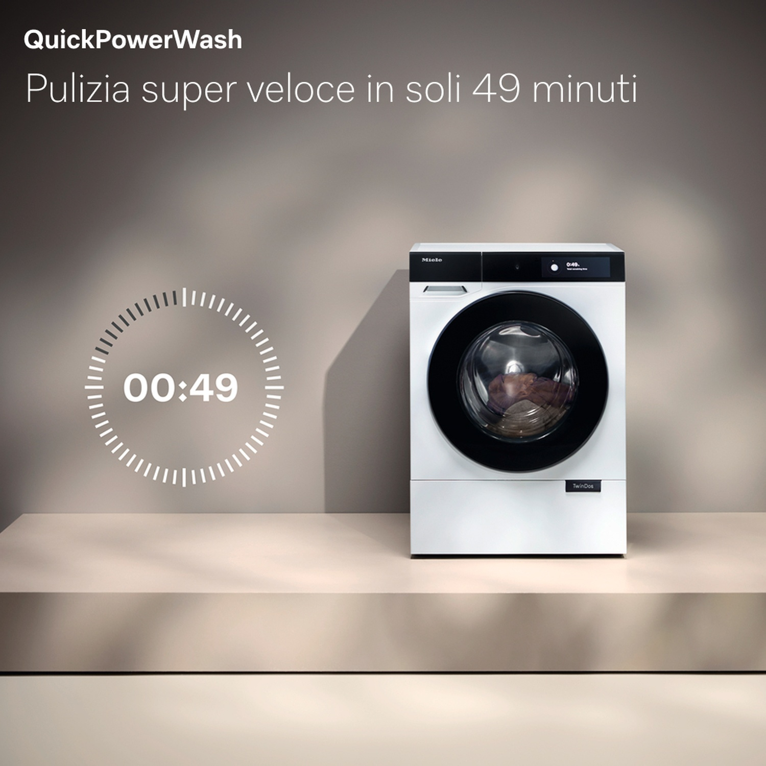Una lavatrice bianca con porta nera. Il timer mostra 00:49. Testo in alto: QuickPowerWash, in basso: TwinDos.