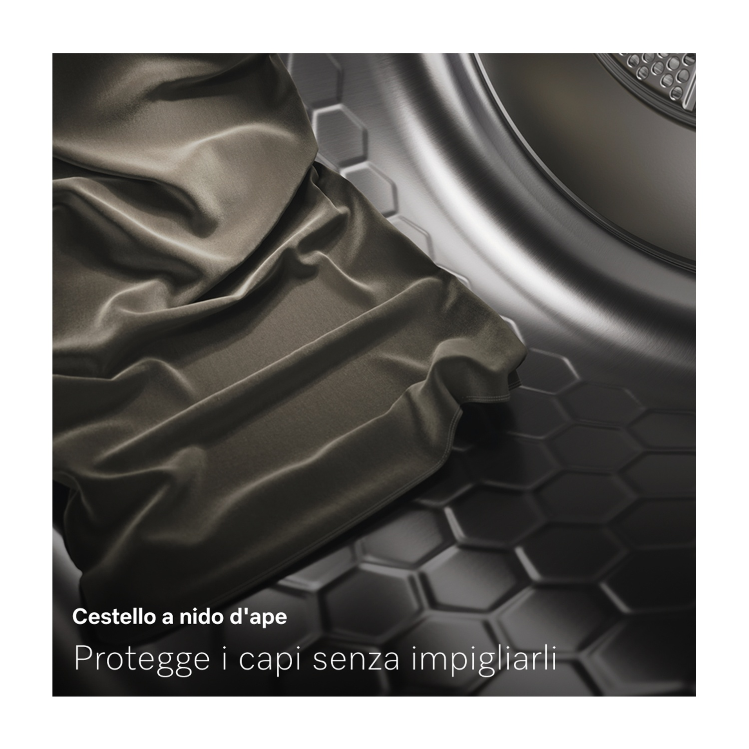 Un tessuto grigio scuro all'interno di un cestello metallico della lavatrice. Il cestello ha un motivo a nido d'ape sul fondo. Il testo recita: Cestello a nido d'ape.