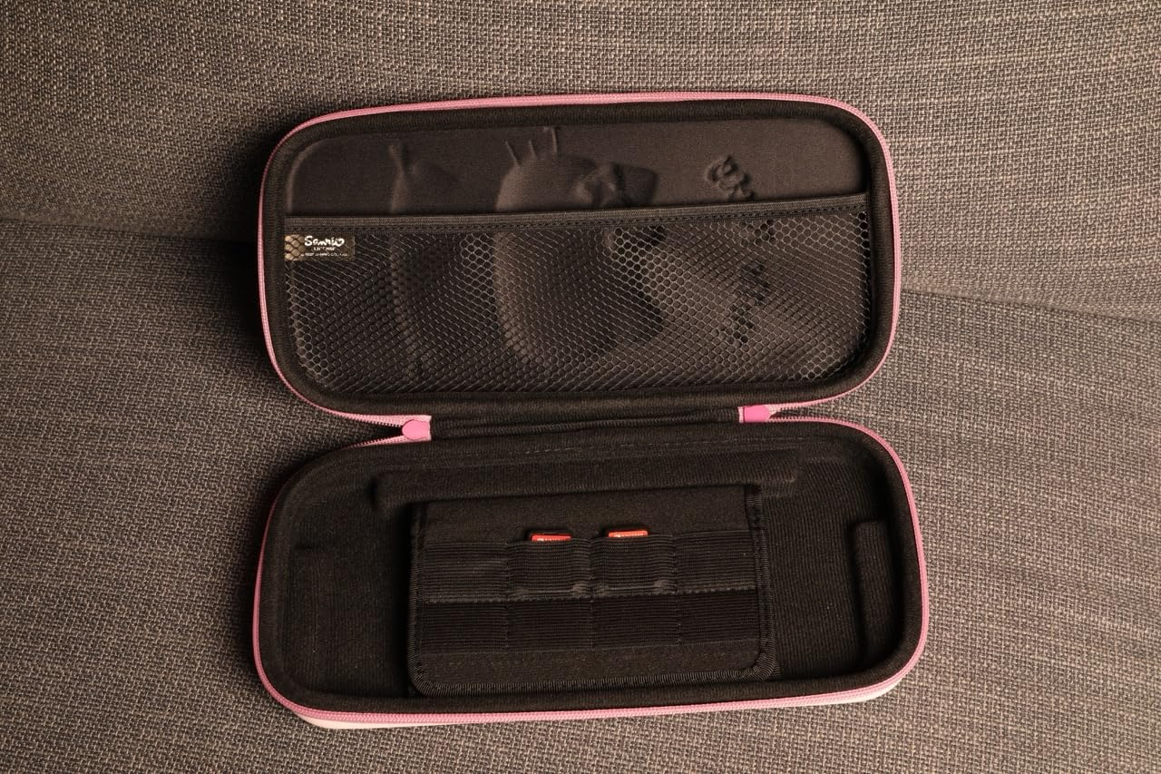 Estuche rosa y negro abierto sobre tela gris. Dentro, un bolsillo de malla y un soporte para cartuchos con dos cartuchos rojos.