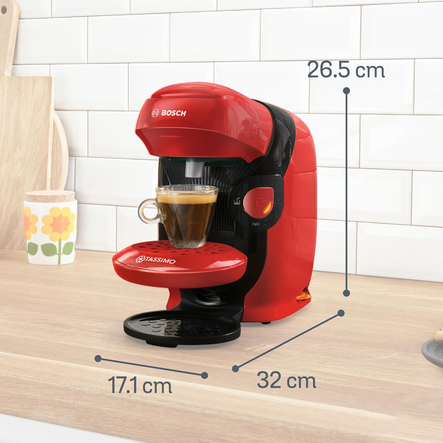Una cafetera roja Tassimo Bosch con una taza de café sobre una encimera de madera. Se indican las dimensiones.