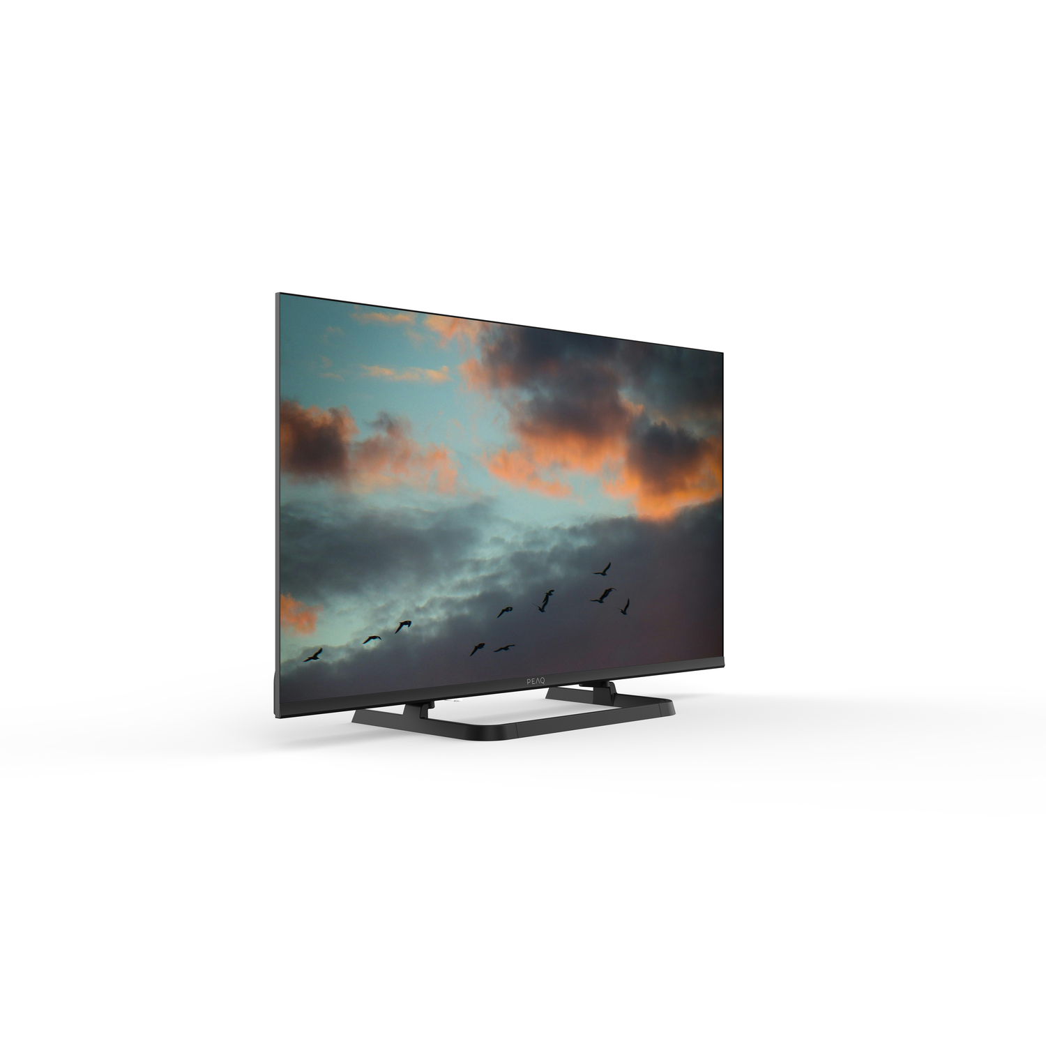 A flat-screen TV displays a sunset with birds. The TV is black, angled, and stands on a white surface.