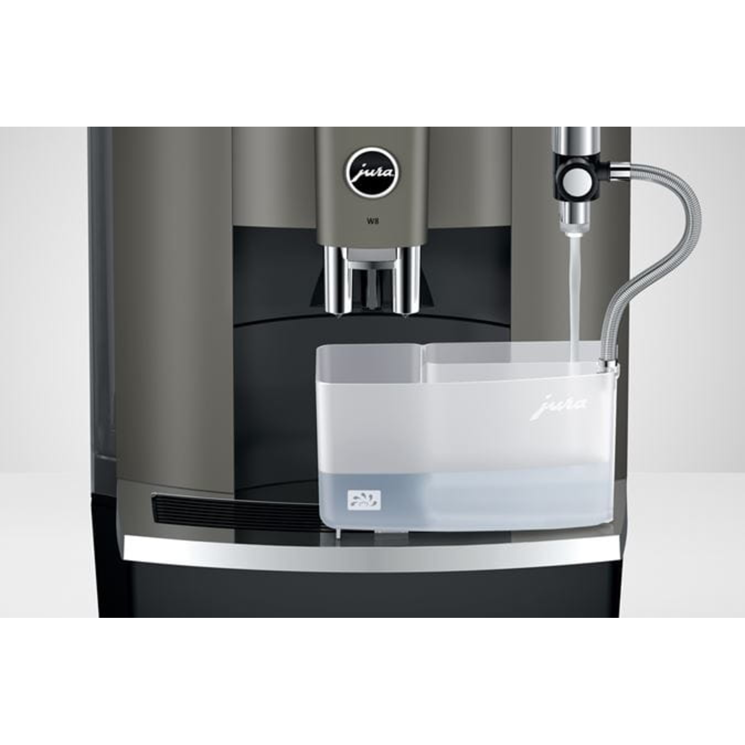 Een Jura koffiemachine met waterafgifte in een transparante container. De machine is grijs en zwart. De container is helder.