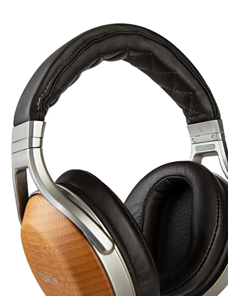 Zbliżenie słuchawek. Czarne skórzane nauszniki i pałąk. Drewniane elementy nauszników i srebrna metalowa rama. Widoczne logo Denon.