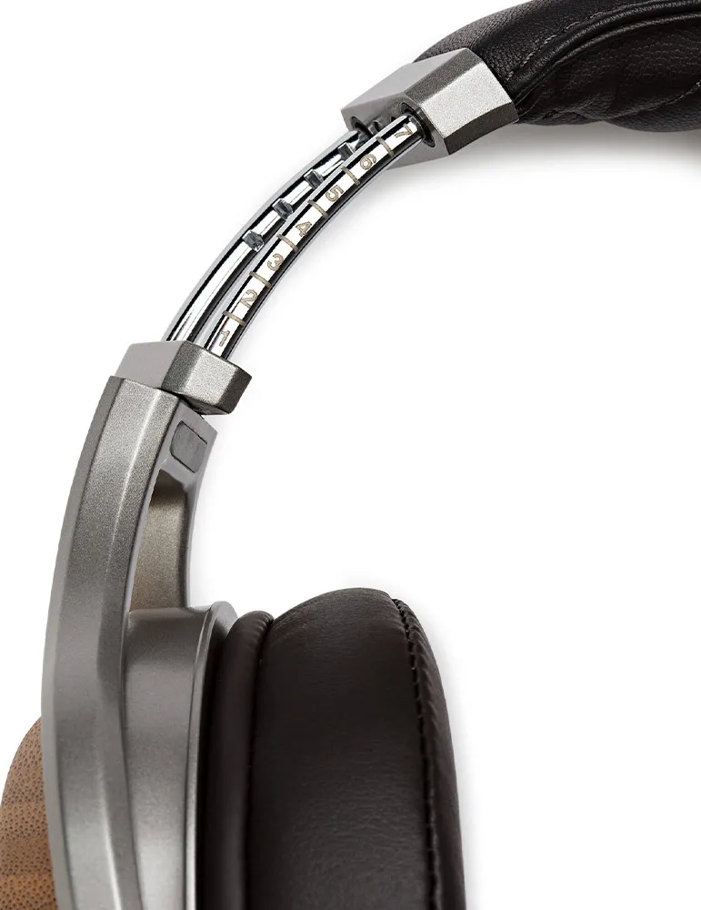 Zbliżenie srebrno-czarnych słuchawek. Widoczna muszla i pałąk. Pałąk ma numery regulacji.