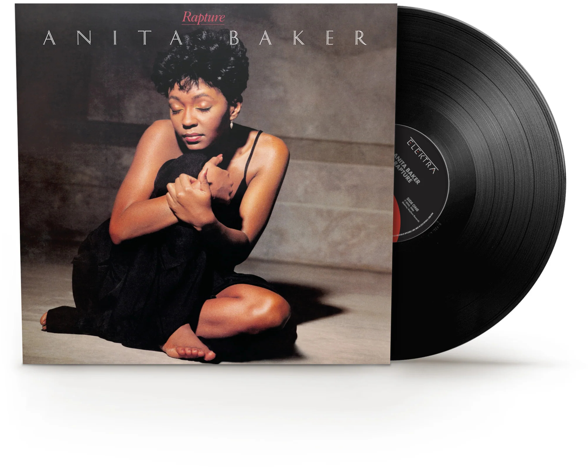 Anita Baker 'Rapture' albumjának borítója, rajta ülve. A borító mellett egy bakelit lemez.