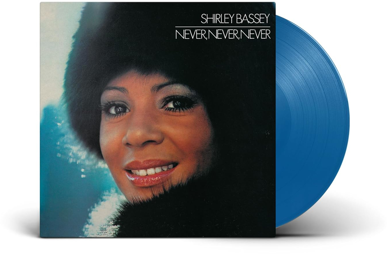 Shirley Bassey "Never, Never, Never" című albumának borítója. Bassey portréja fekete szőrmekalapban, kék bakelitlemezzel.