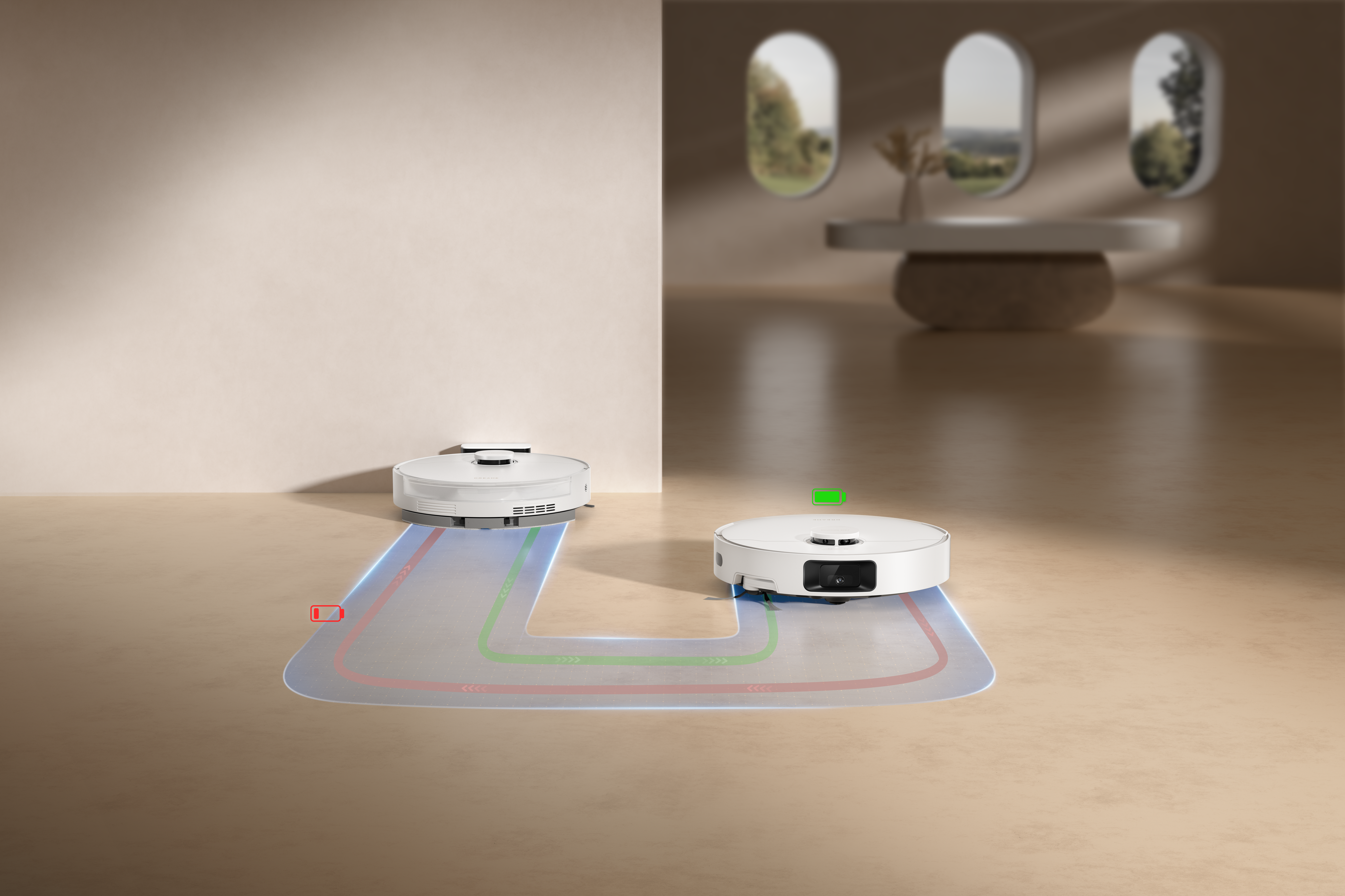 Dwa białe roboty sprzątające na beżowej podłodze, ze ścieżkami nawigacyjnymi. Tło: beżowa ściana, okna i stół.