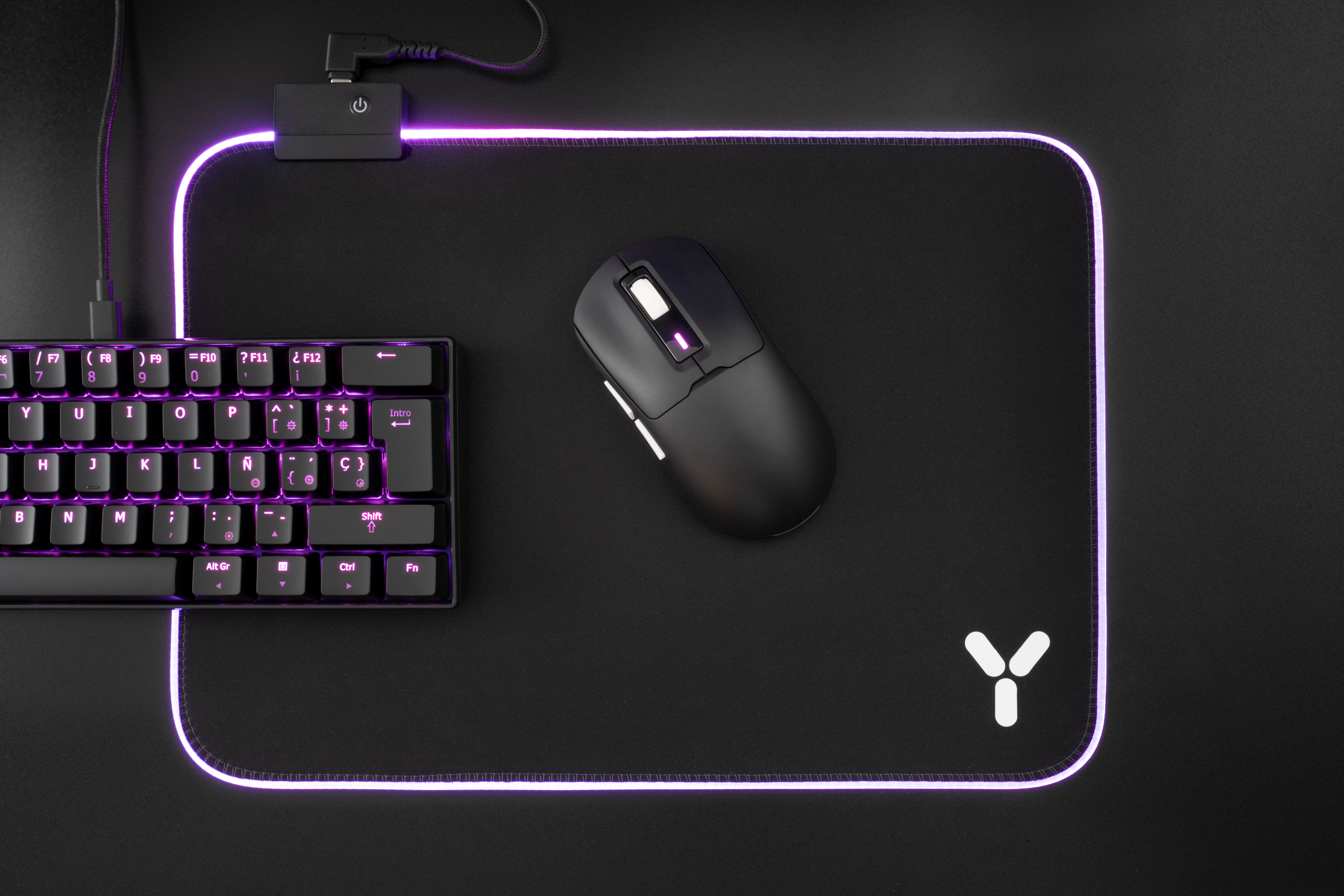Czarna mysz, klawiatura i podkładka pod mysz z fioletową obwódką świetlną i białym logo na czarnej powierzchni.
