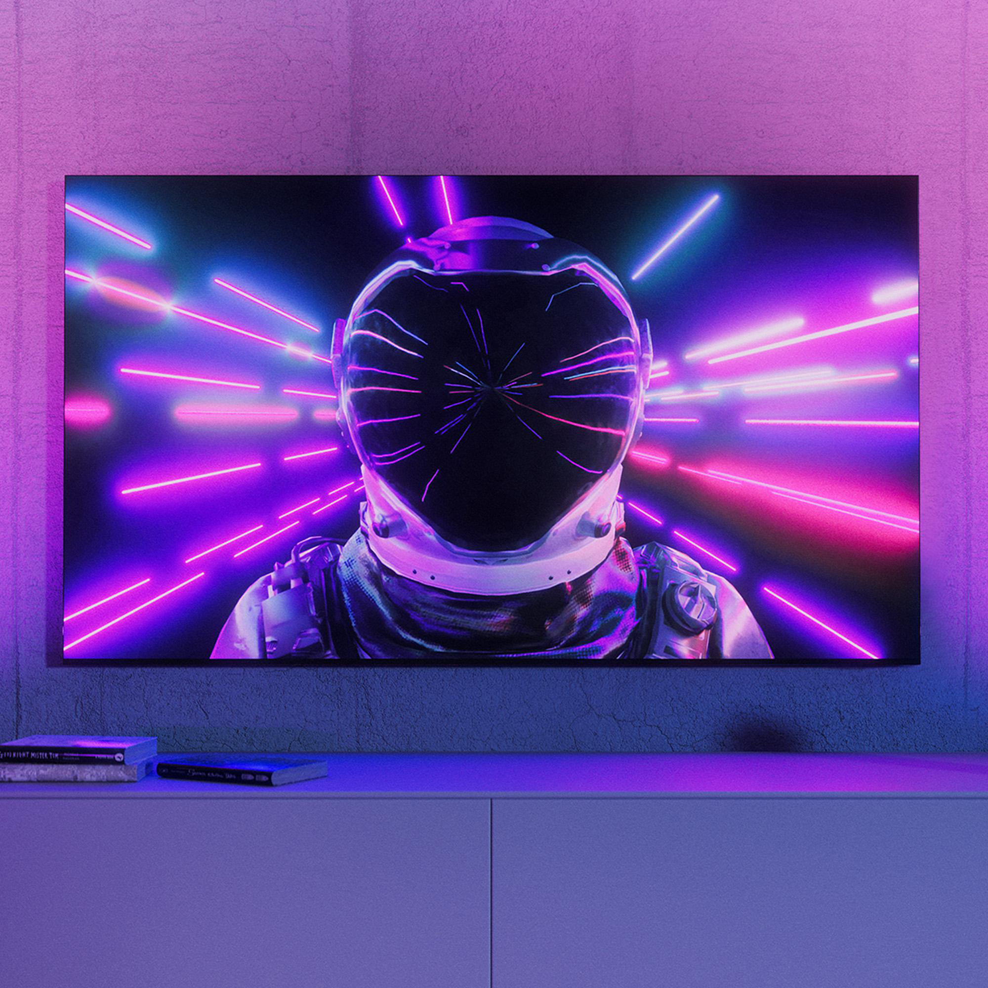 Astronaut auf dem Fernseher mit Neonlichtern. Bücher auf dem Regal unter dem Fernseher. Lila Wand und Schrank im Raum.
