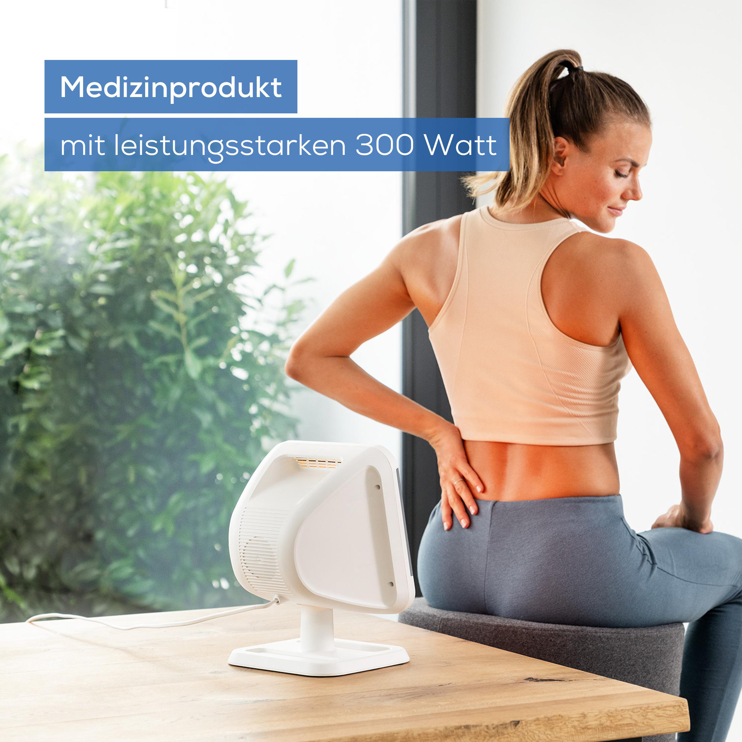 Frau mit Rückenschmerzen sitzt neben einem weißen medizinischen Gerät. Text auf dem Bild lautet 'Medizinprodukt mit 300 Watt'.