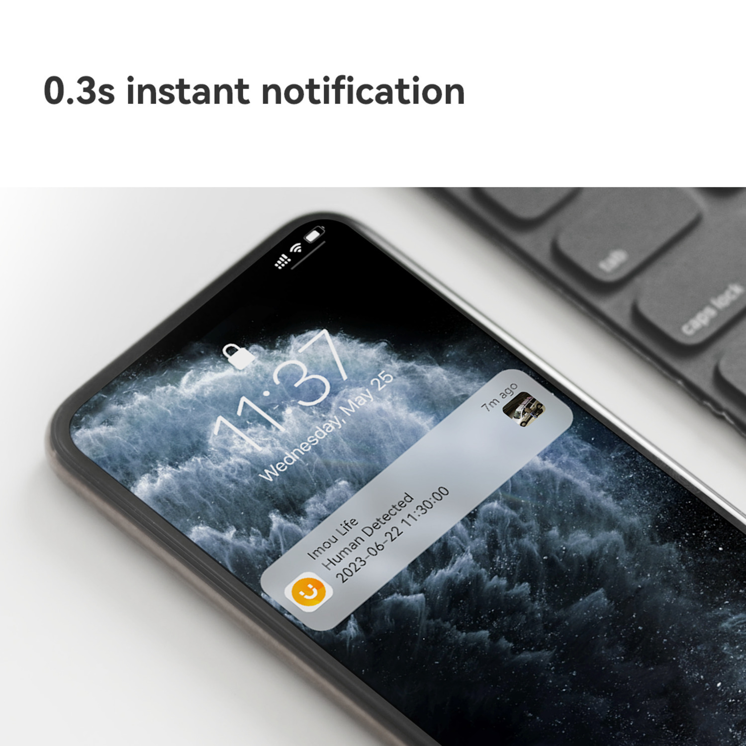 Een smartphone toont een melding van Imou Life. De melding luidt "Mens gedetecteerd". Een toetsenbord is zichtbaar op de achtergrond.