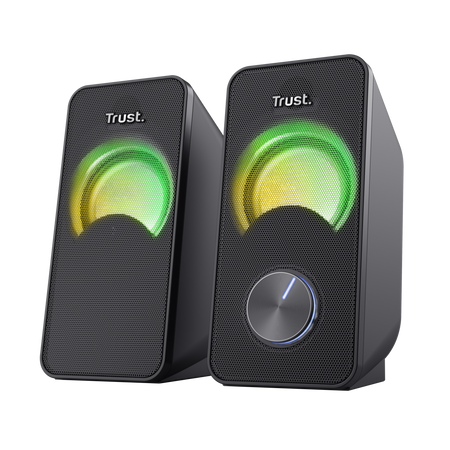 Dwa czarne głośniki Trust z zielonym i żółtym światłem. Jeden ma regulację głośności z niebieskim wskaźnikiem.