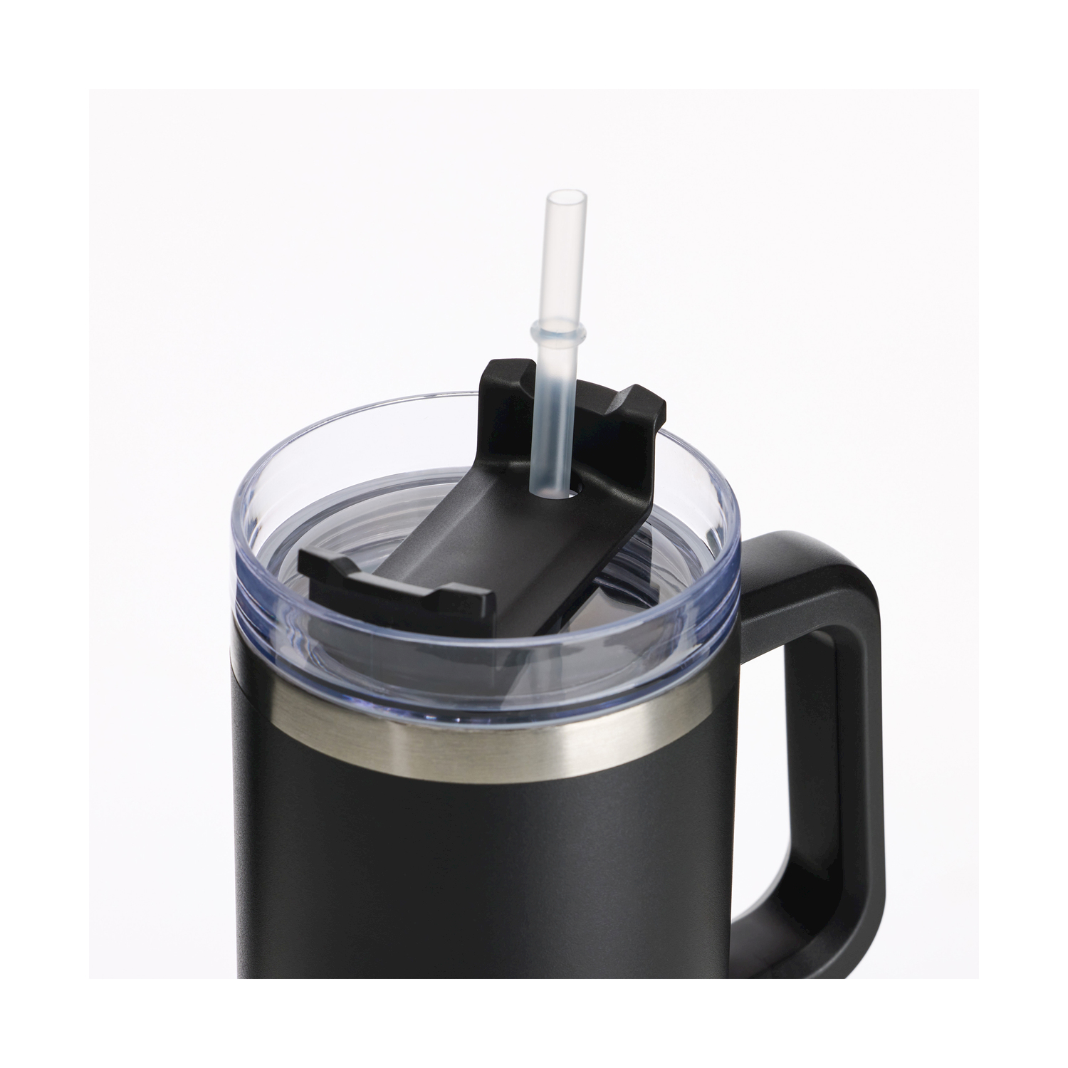 Tazza isolante nera con coperchio trasparente e cannuccia, manico a destra. Fascia argentata al centro. Sfondo bianco.