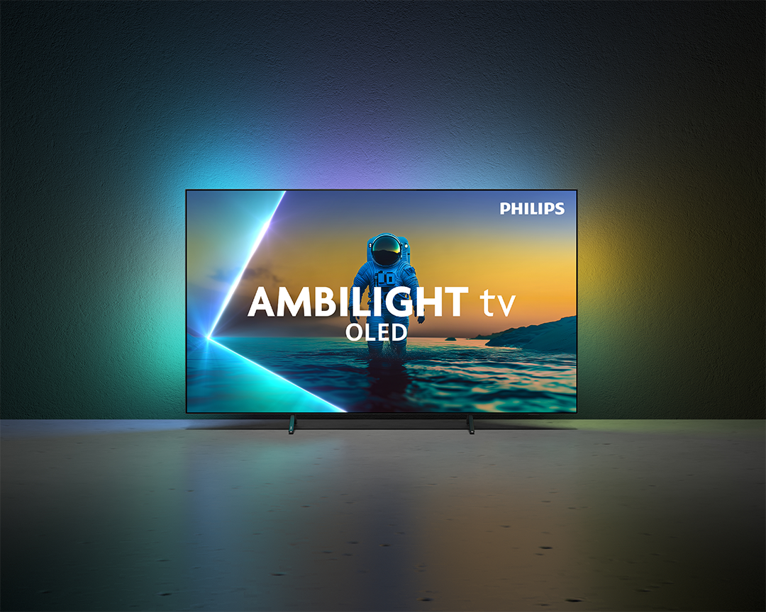 Egy Philips Ambilight OLED TV egy űrhajóst jelenít meg a strandon. A TV betonpadlón van, a falon színátmenetekkel.