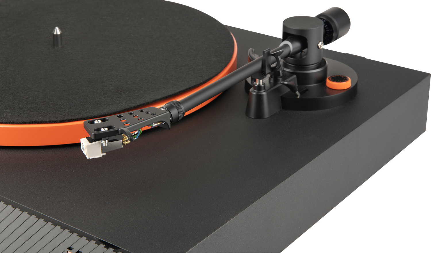 Tocadiscos negro con detalles naranjas. El brazo de la aguja está extendido. El fondo es gris.