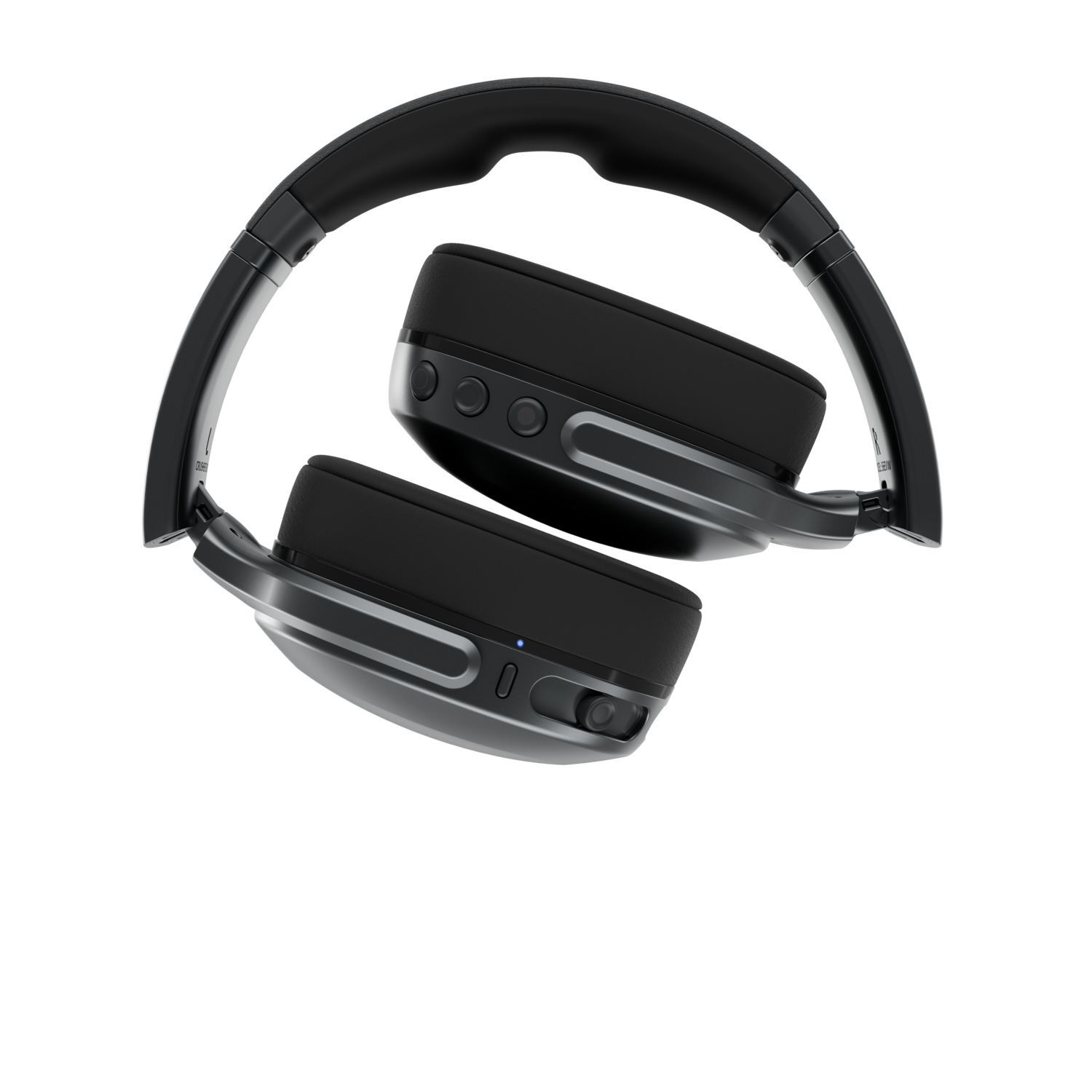 Casque noir sur fond noir. Le casque est plié, les écouteurs vers le haut.