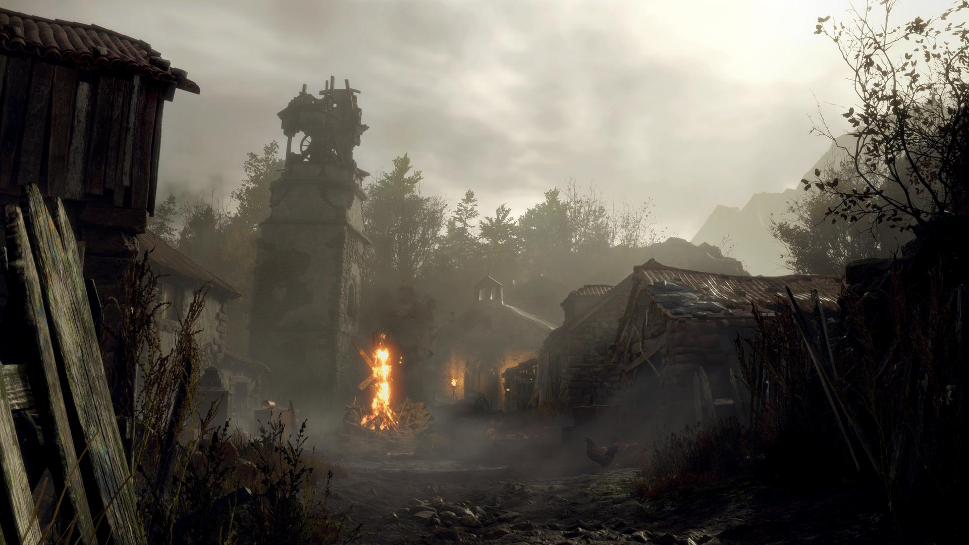 Dorflandschaft mit brennendem Feuer, alten Gebäuden, einem Turm und bewölktem Himmel. Die Szene ist diesig, mit Bergen im Hintergrund.