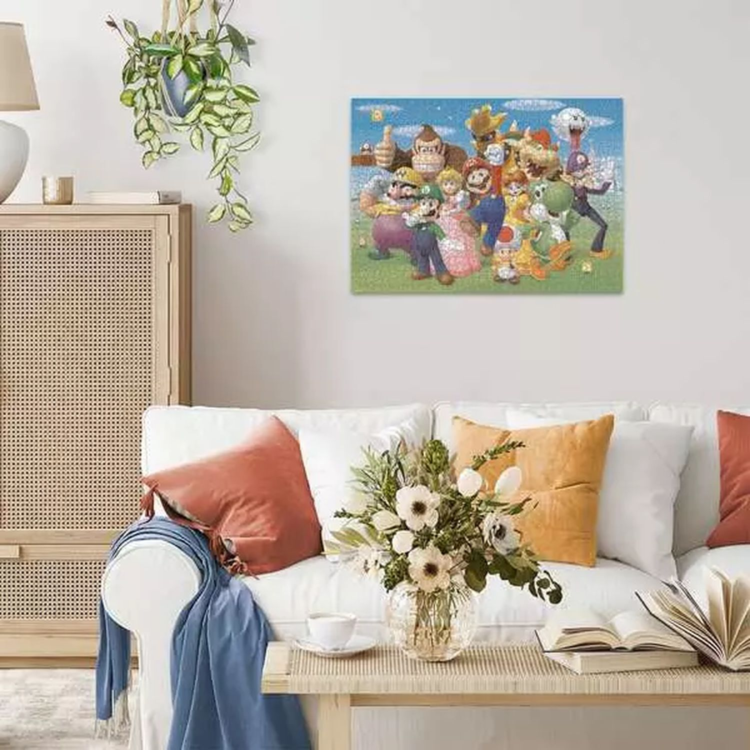 Living room with a white sofa, pillows, table with flowers, and a painting of Mario characters.