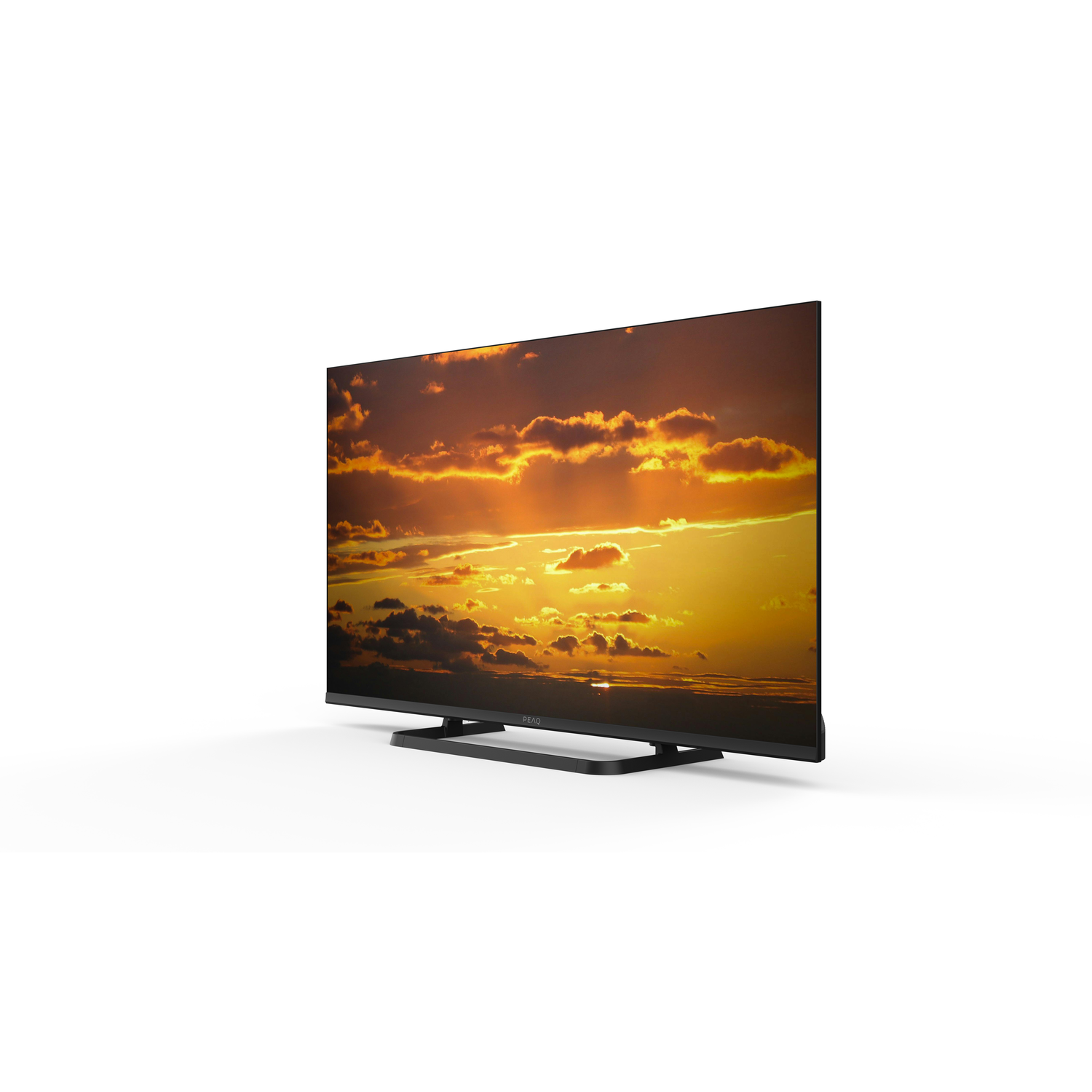 A black flat-screen TV displays a sunset scene. The sky is orange and yellow with clouds. The TV sits on a white surface.