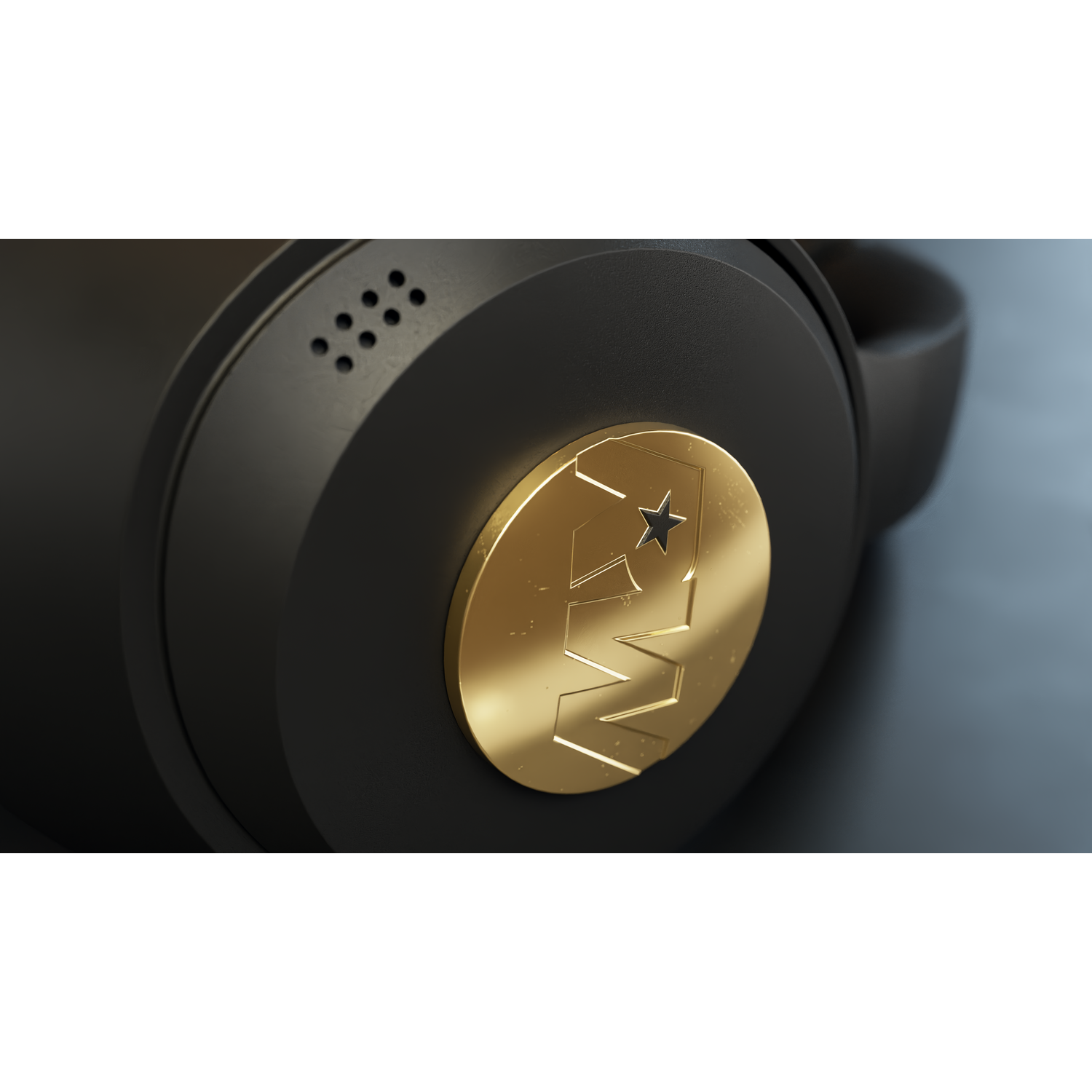 Black headphones with a gold emblem showing a star and letters. The background is dark and blurry.