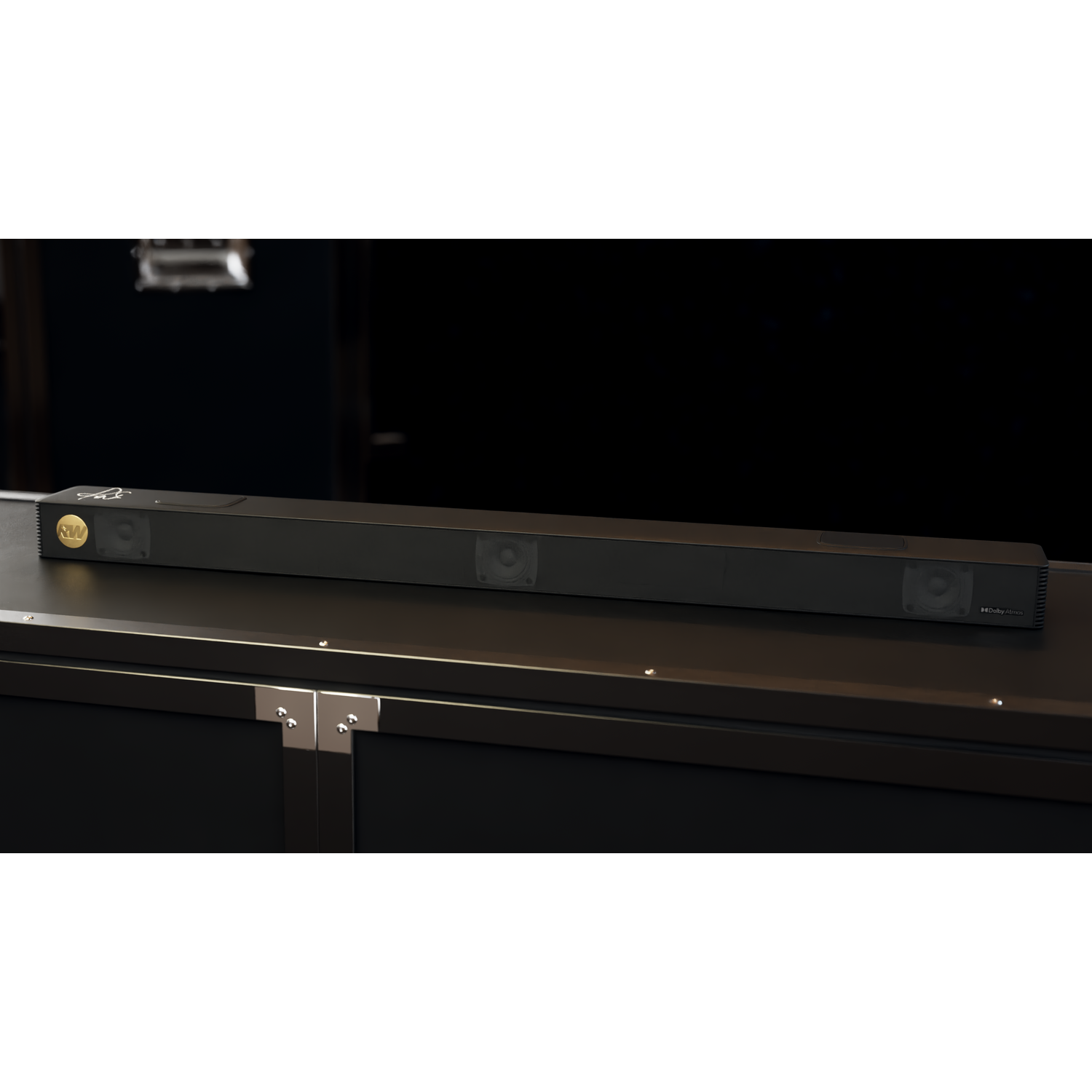 Een zwarte soundbar ligt op een donker oppervlak. Hij heeft luidsprekers en een gouden logo. De achtergrond is donker.
