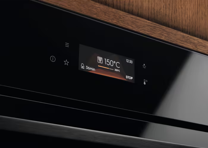 Czarny panel sterowania piekarnika wyświetla ustawienia: 150°C, timer 36min i ikony. Drewniane wykończenie u góry.