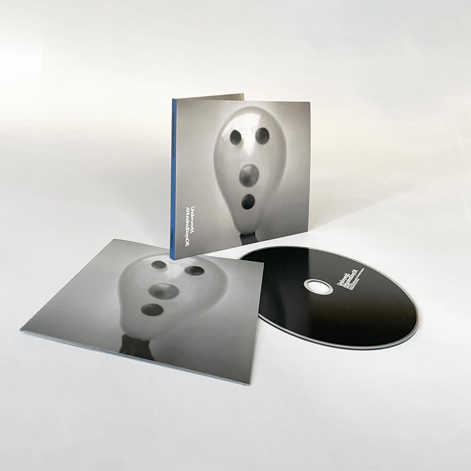 Ein CD-Cover und eine CD. Auf dem Cover ist ein weißer Ballon mit schwarzen Kreisen abgebildet. Die CD ist schwarz mit weißem Text.