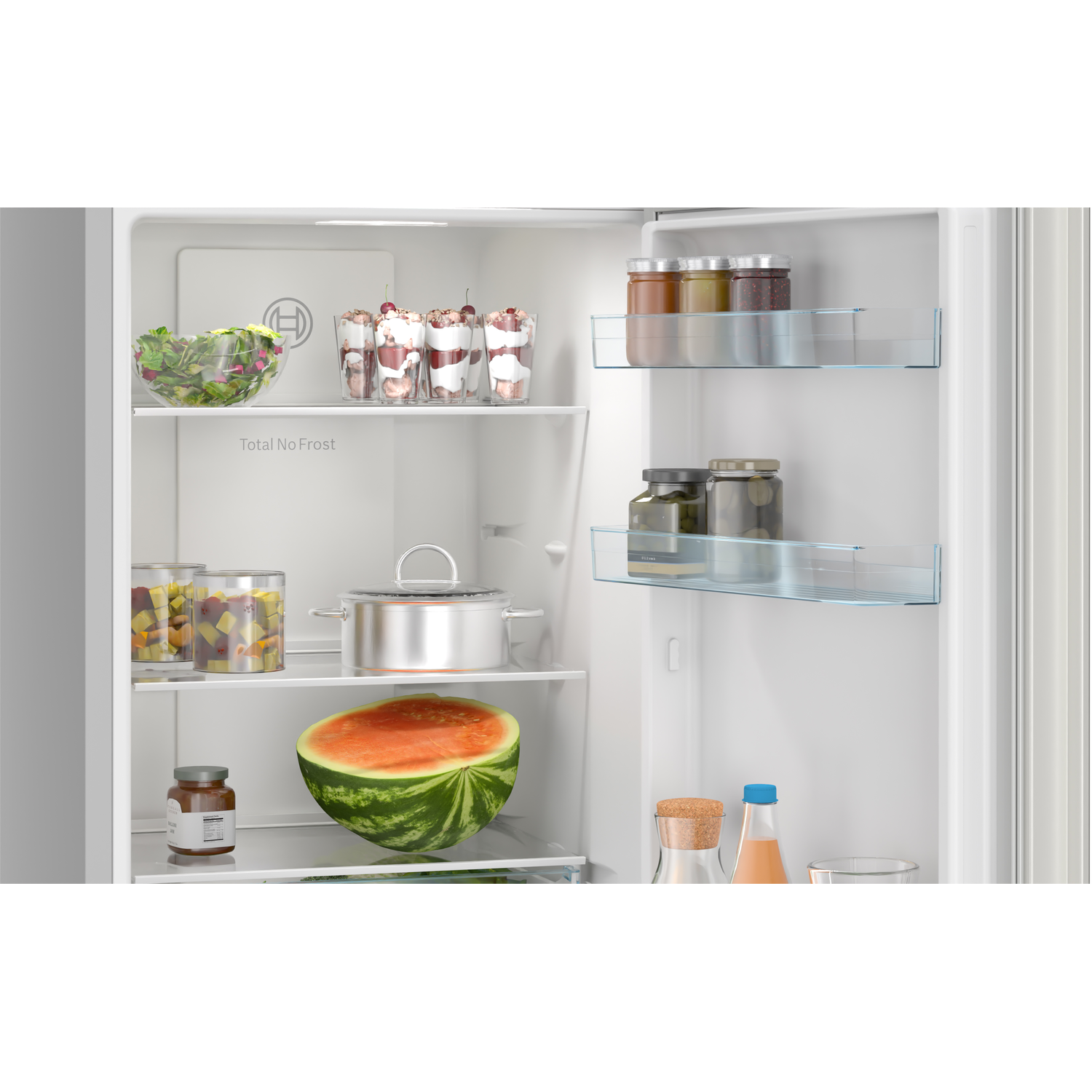 Refrigerator interior with food items: watermelon, jars, salad, and desserts. Shelves are visible.