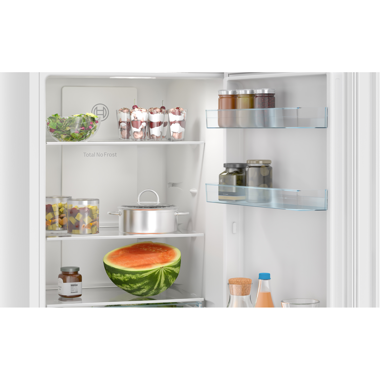 Inside a refrigerator, a half watermelon, jars, desserts, and a pot are visible. Shelves are filled with food items.