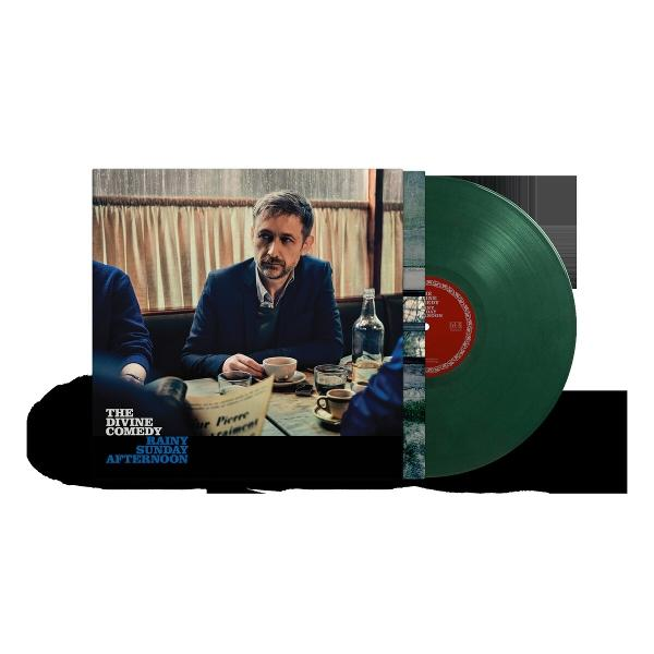 Mann in einem Café, der mit anderen an einem Tisch sitzt, neben einer grünen Schallplatte und dem Albumcover. Kaffeetassen und Flasche stehen auf dem Tisch.