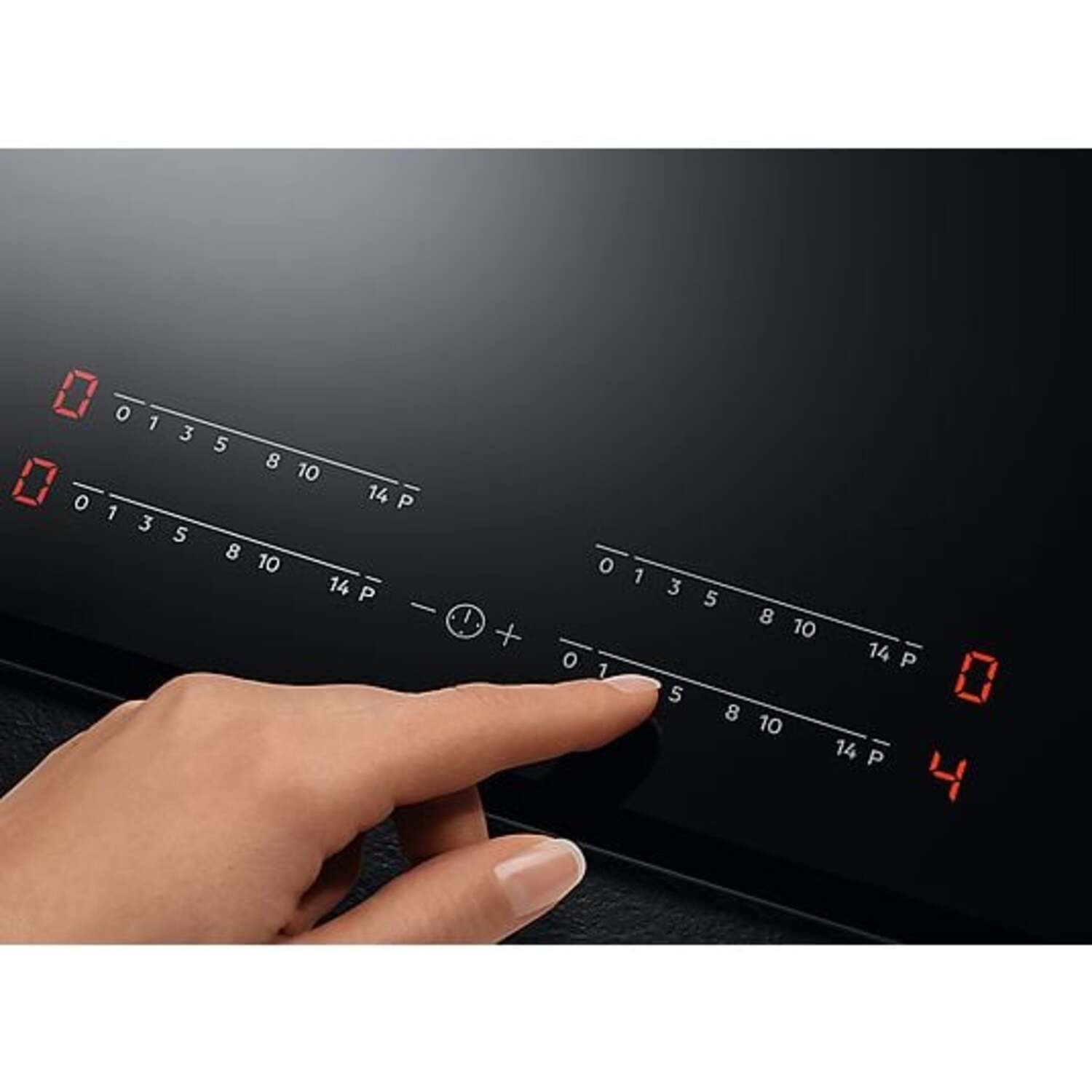 A hand touching a black induction hob, with digital displays, showing numbers. The display reads 0 and 4.