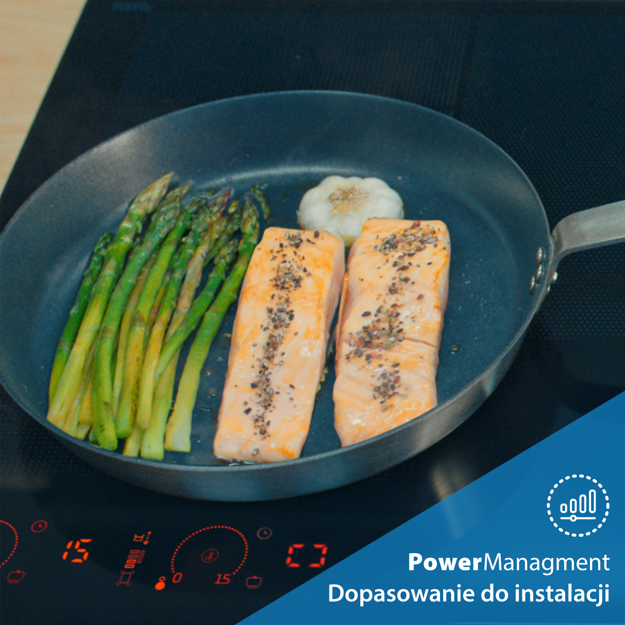 Patelnia ze szparagami, łososiem i czosnkiem na czarnej płycie kuchennej. Płyta kuchenna pokazuje liczby. Niebieska nakładka z tekstem.