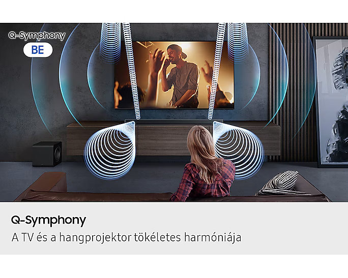 Nő tévét néz, hanghullámok jönnek ki belőle. Balra egy mélynyomó. Szöveg: Q-Symphony. A háttér egy szoba.