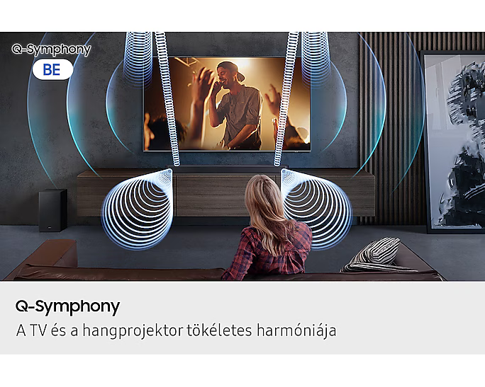 Egy nő tévét néz. A kép hanghullámokat mutat a tévé körül, egy soundbarral és mélynyomóval. A Q-Symphony szavak láthatók.
