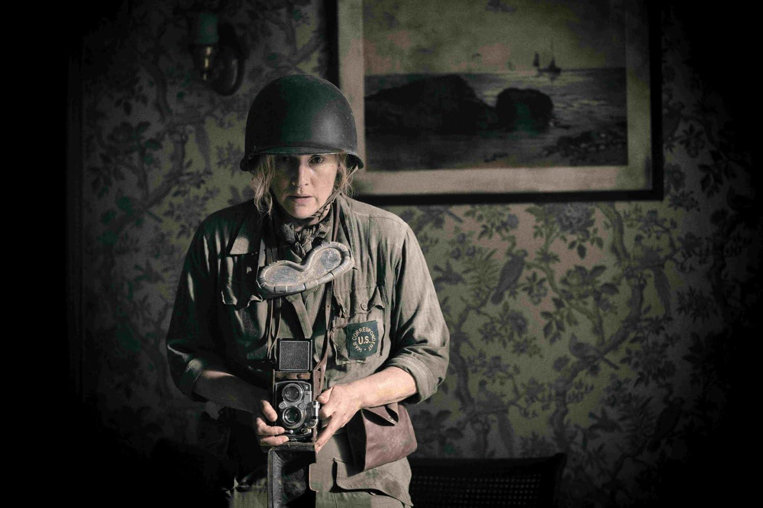 Frau in Uniform hält Kamera. Sie trägt Helm und Brille. Hintergrund zeigt Bild und Blumengardine.