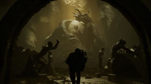 Inside a cavern, a dragon statue towers. Silhouetted figures stand before it. Light shines from above, creating a dramatic scene.