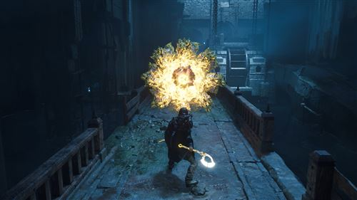 A figure with a glowing staff faces a large, bright explosion. The scene is a dimly lit, stone structure with water and a bridge.