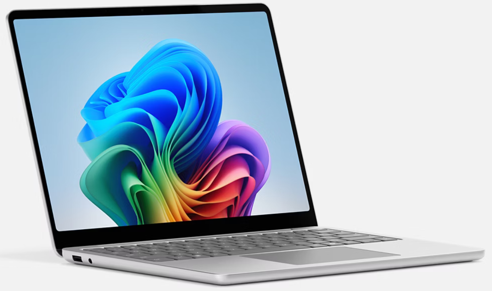 Ezüst laptop színes, absztrakt háttérképpel. A képernyő nyitva van, kék, zöld és lila dizájnt mutat.